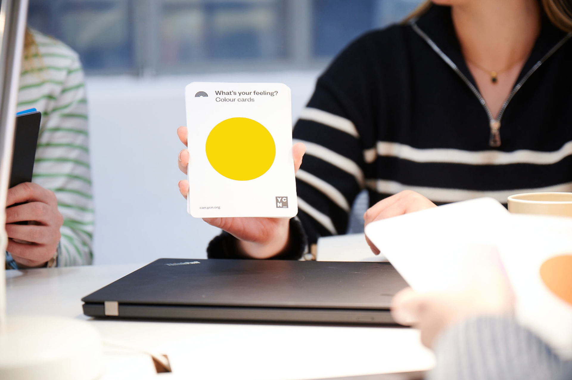 A participant holding a DISC colour card with a yellow circle