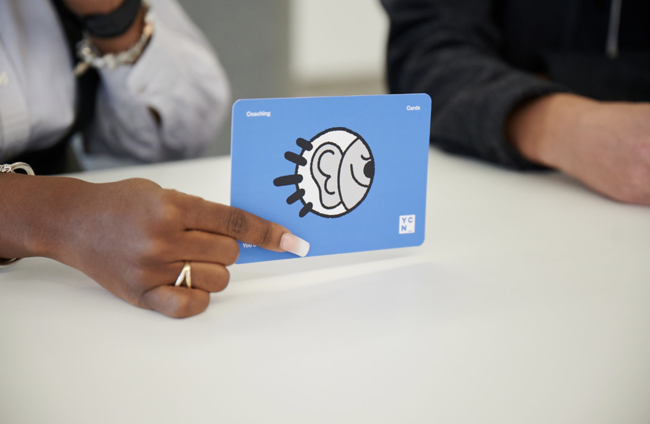 YCN coaching card being shared across a table