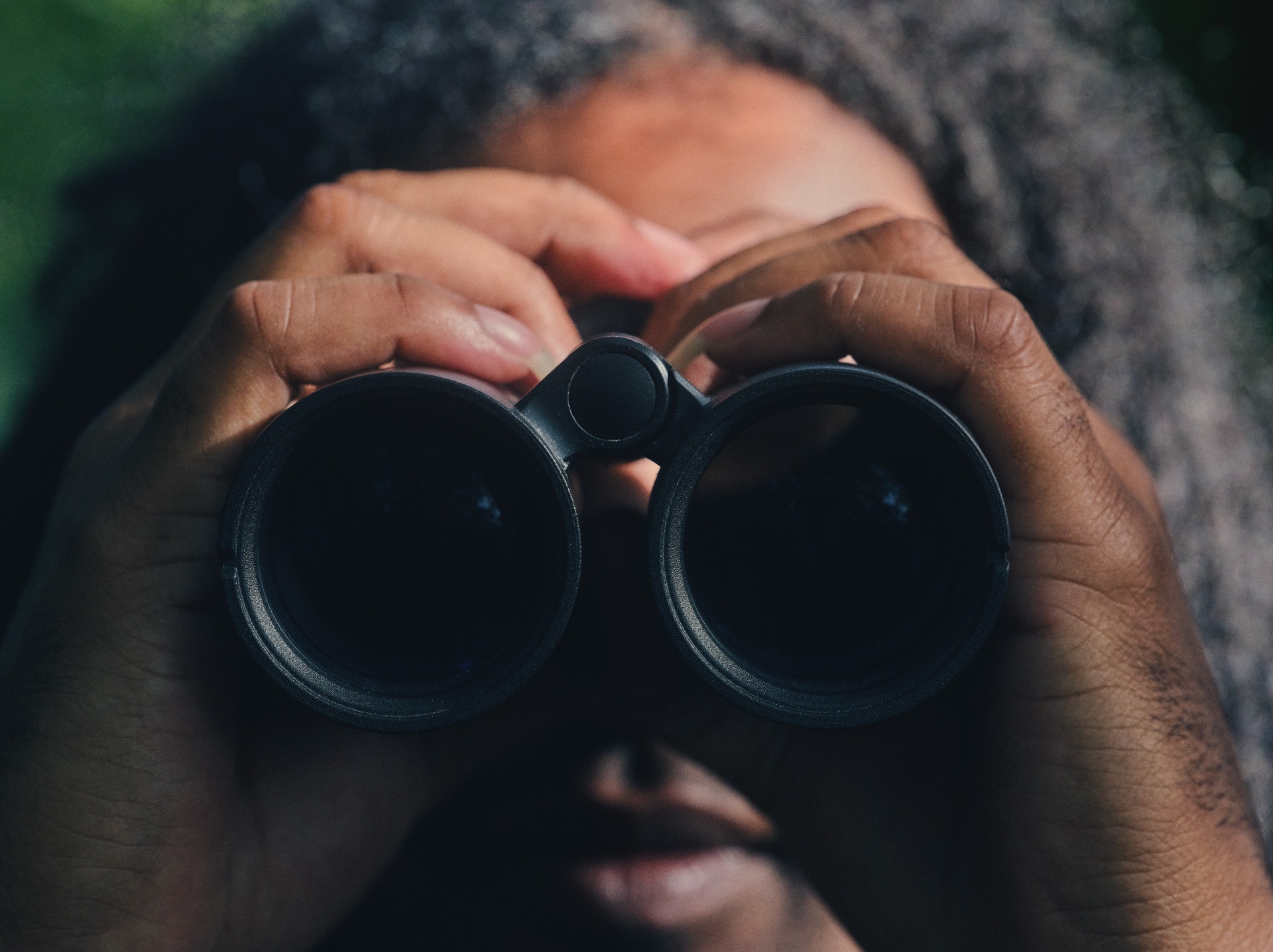Close-up of Nadeem holding binoculars to his eyes